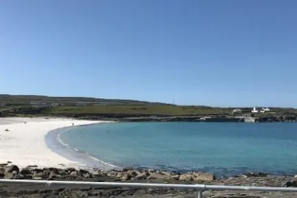 a sandy beach next to a body of water