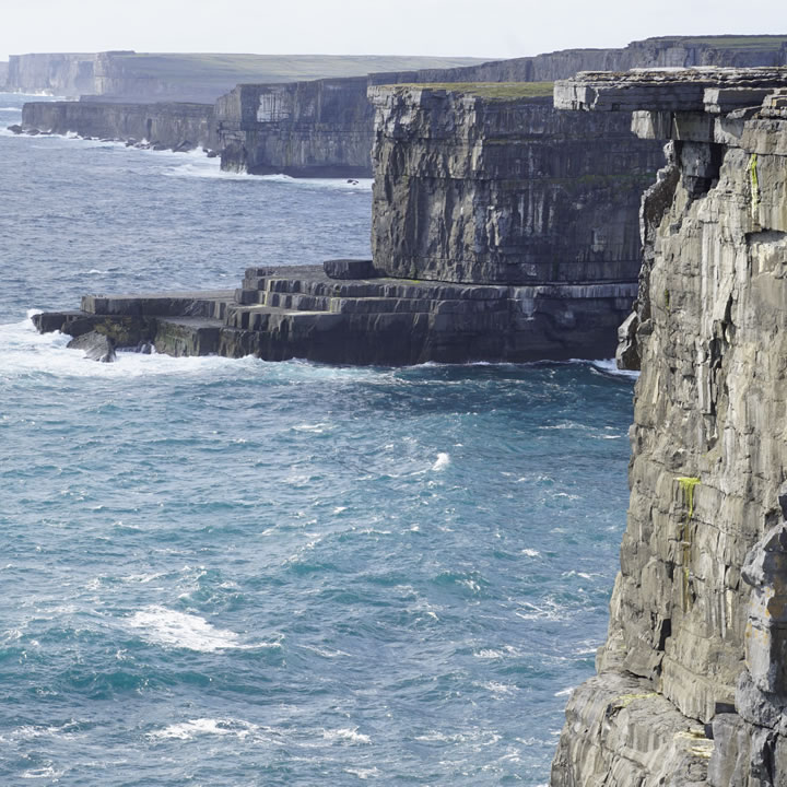 a cliff next to a body of water