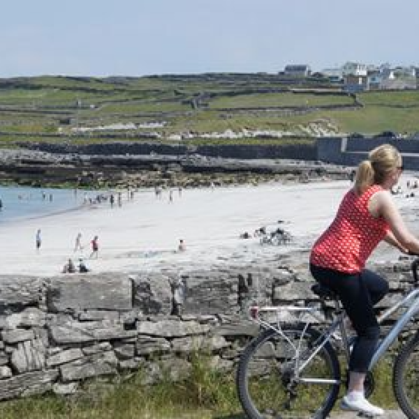 a person sitting on a rock next to a bicycle