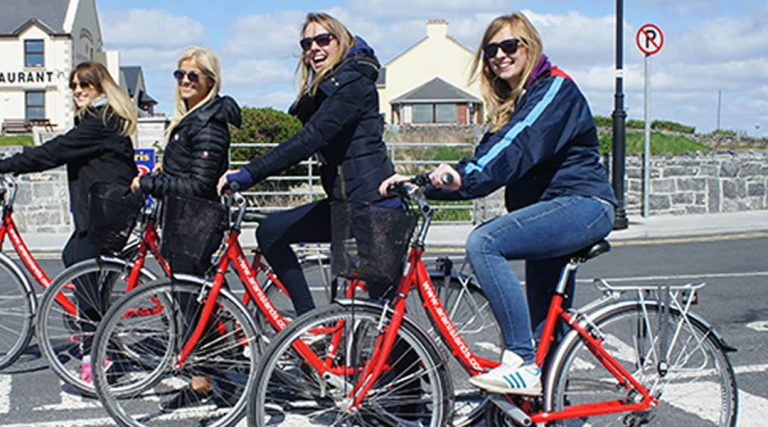 a group of people riding on the back of a bicycle