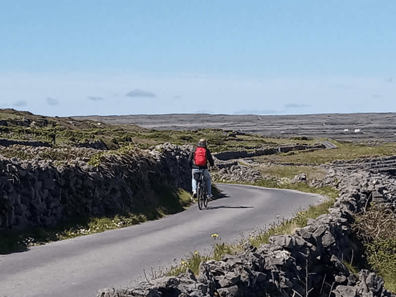 a man riding a bike down a dirt road