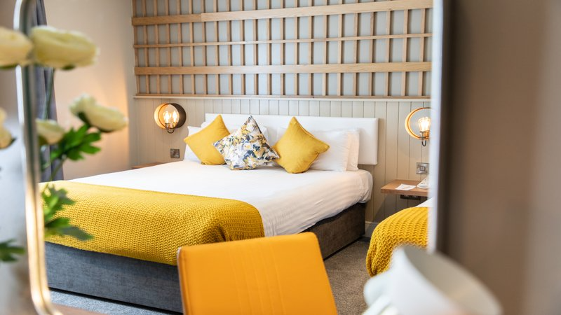 a bedroom with a bed and a chair in a room