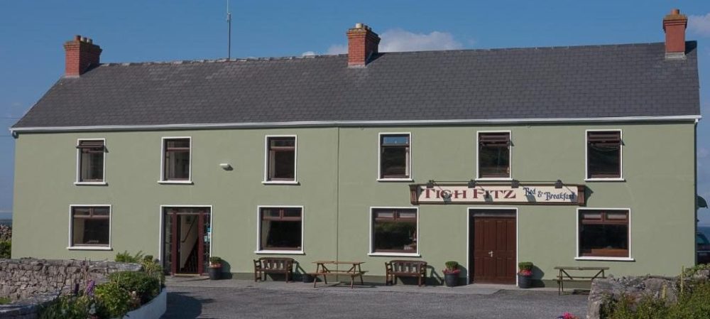 a small house in front of a brick building